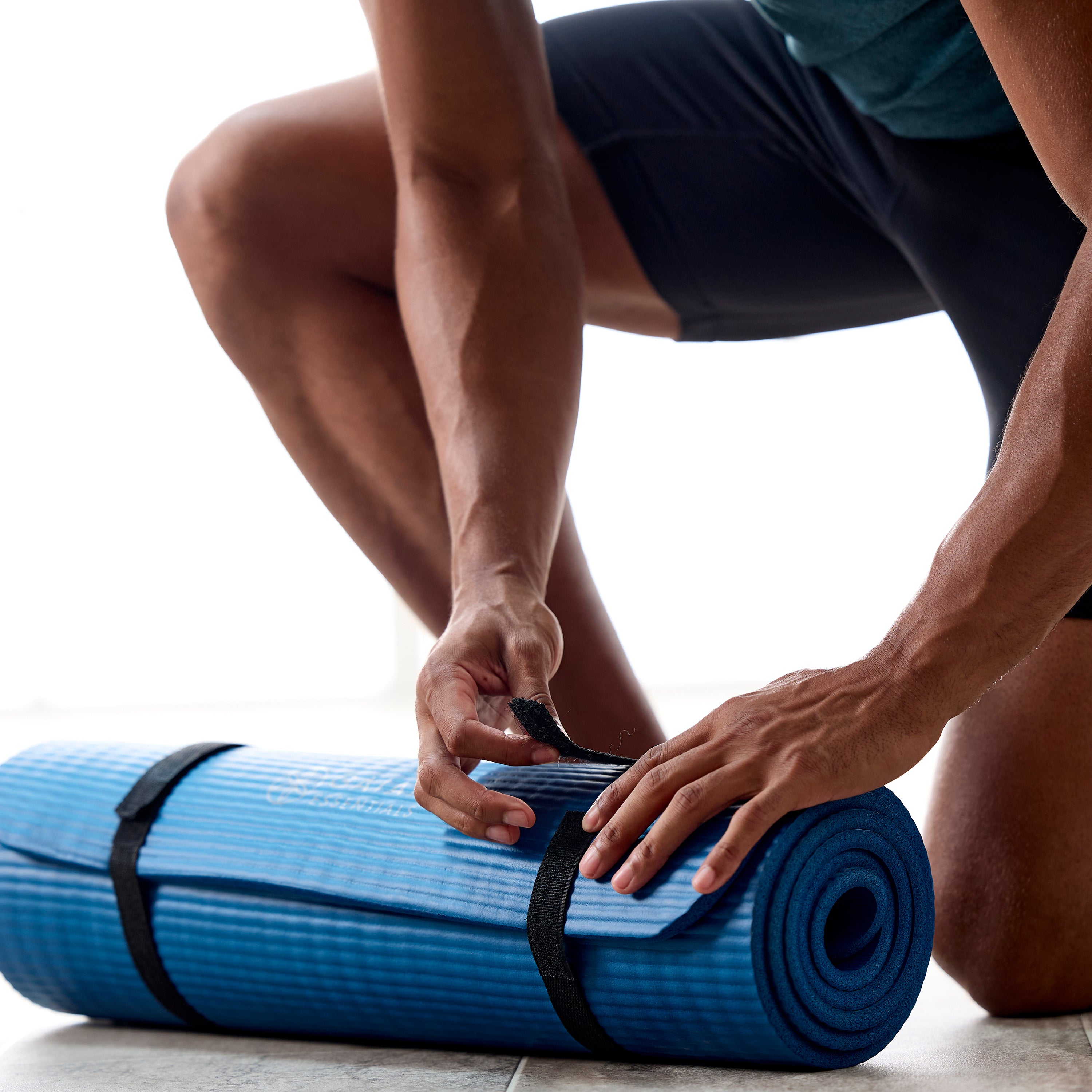 Up close of person attaching the sling to the Gaiam Essentials Fitness Mat